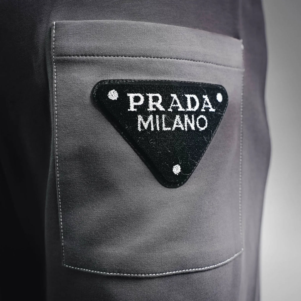 Dark gray pants pocket with triangular Prada Milano logo patch