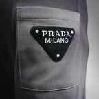 Dark gray pants pocket with triangular Prada Milano logo patch