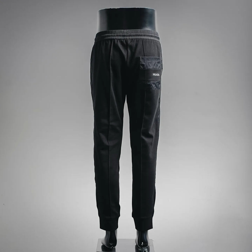 Prada black pants, side view with PRADA logo patch near pocket