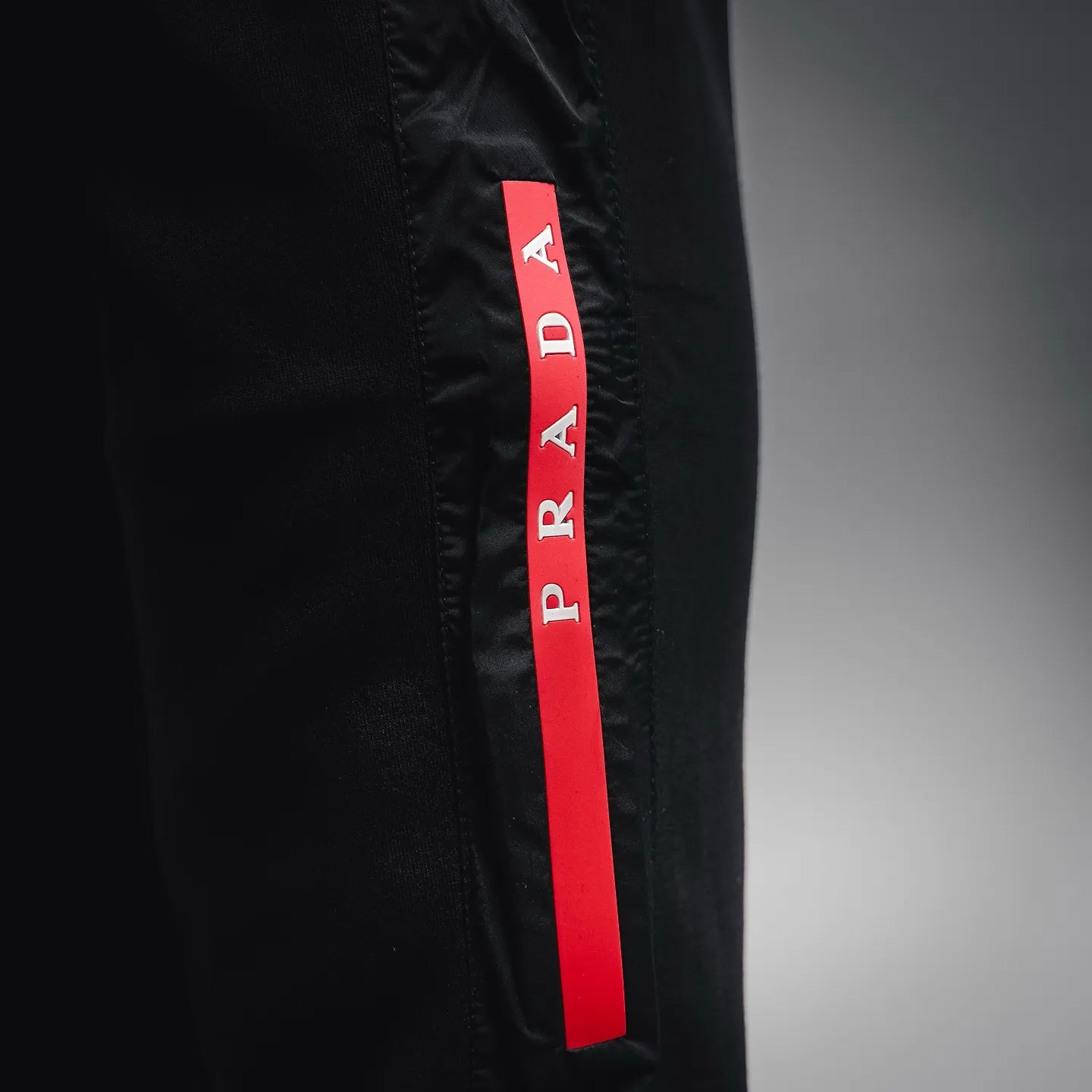 Prada black pants with red PRADA fabric tag on the side