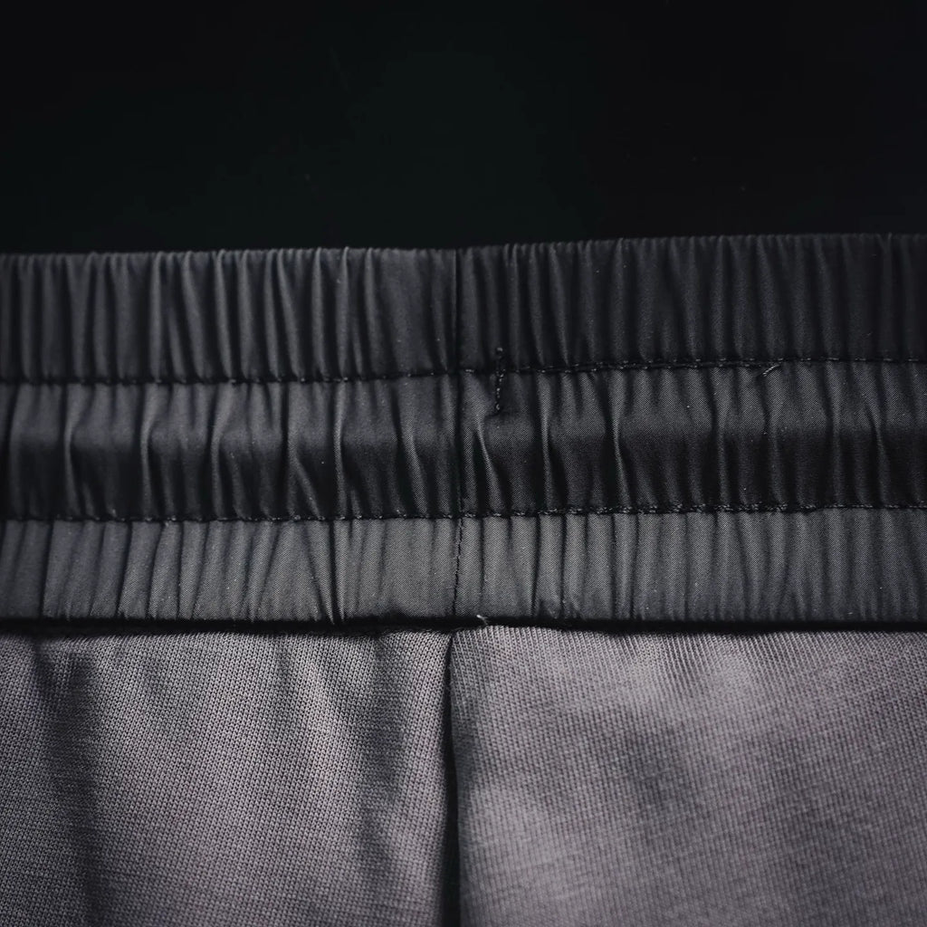 Prada elastic waistband seam detail on dark gray jogger pants