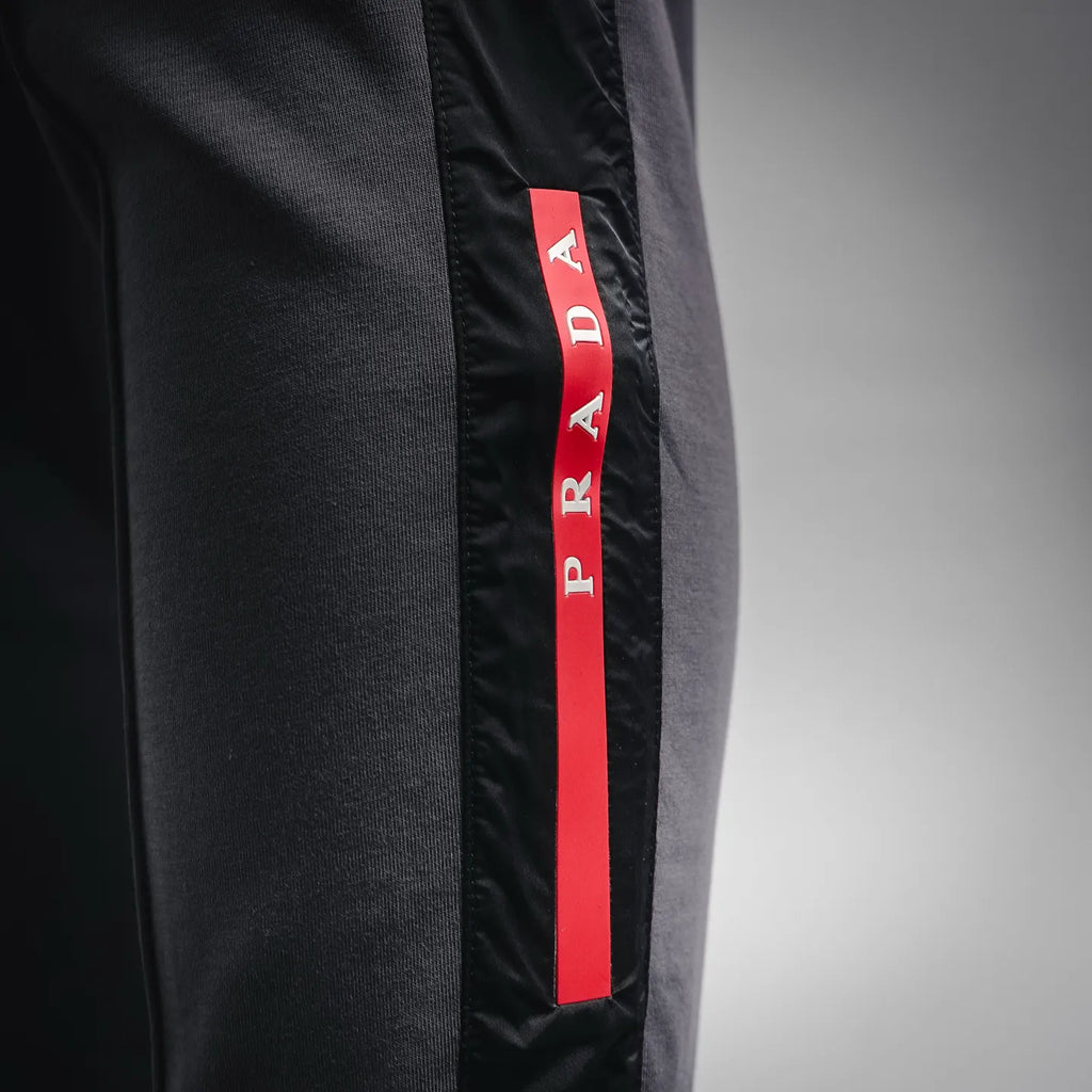 Prada dark gray pants with vertical red PRADA logo stripe on side panel