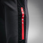 Prada dark gray pants with vertical red PRADA logo stripe on side panel
