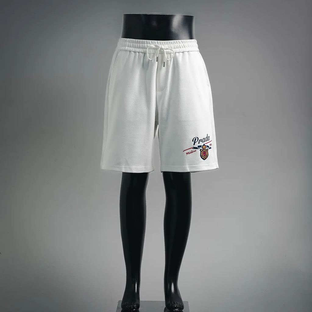 White Prada shorts with elastic waistband and drawstring, front logo patch detail.
