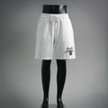 White Prada shorts with elastic waistband and drawstring, front logo patch detail.