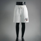 White Prada shorts with elastic waistband and drawstring, front logo patch detail.