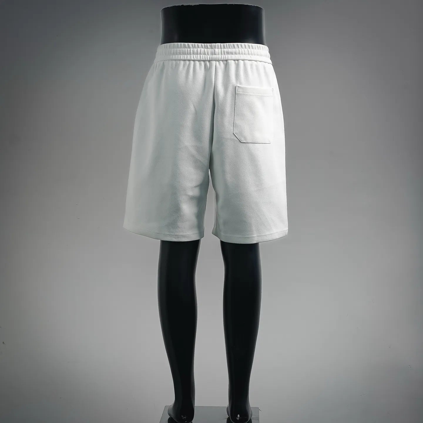 White Prada shorts with elastic waistband and side pocket, back view.