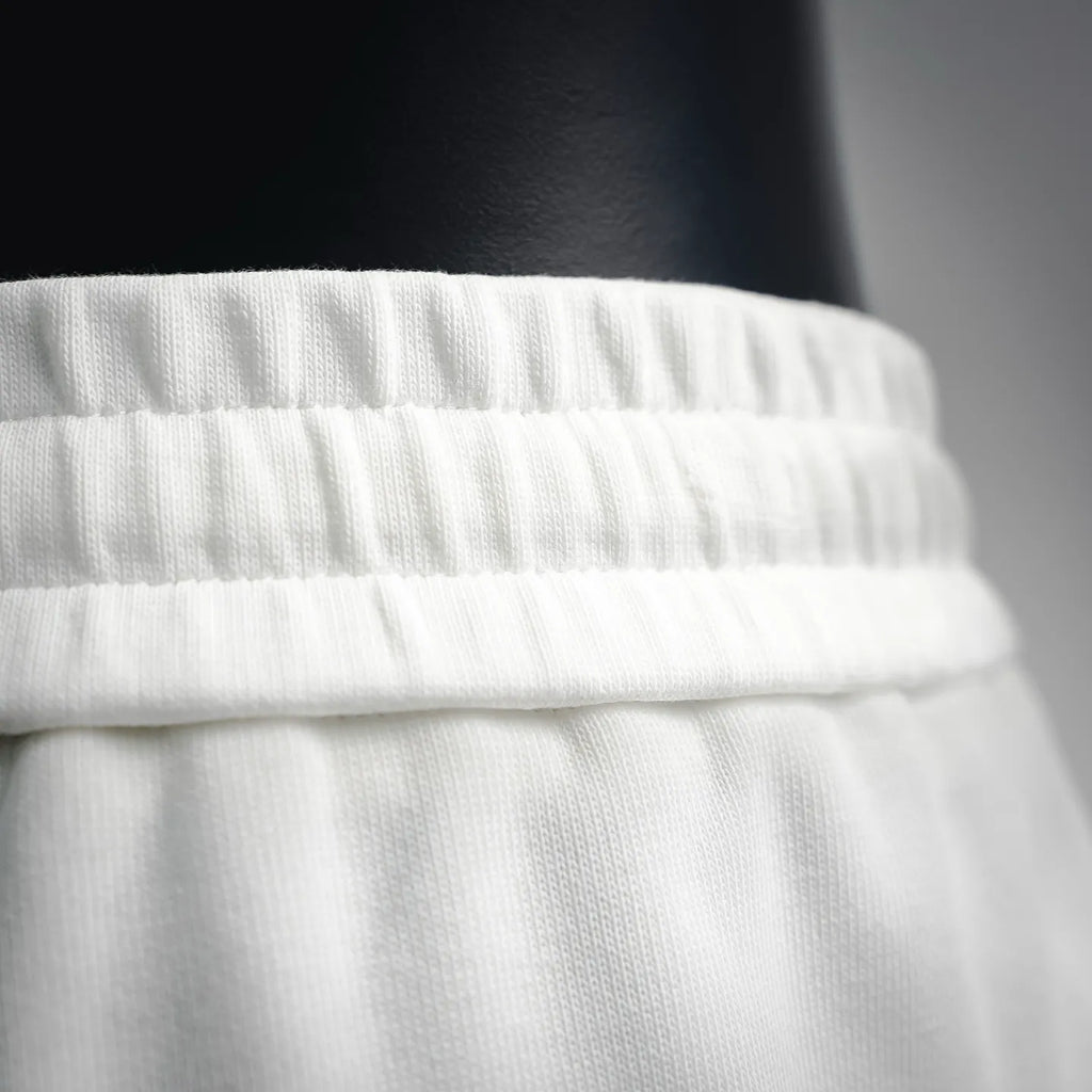 White Prada shorts waistband close-up with gathered elastic detail.