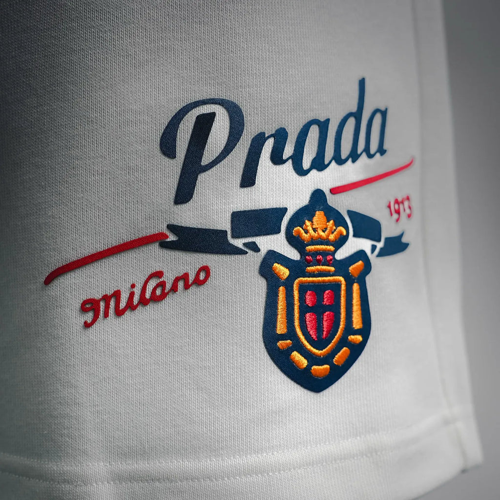 White Prada shorts front graphic logo print in blue and red.