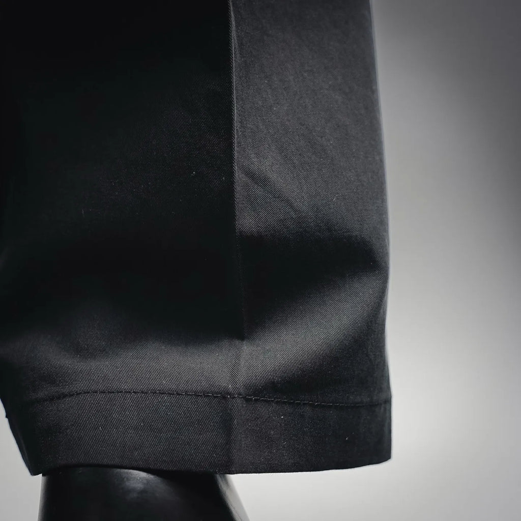 Black pant hem with cuffed bottom and visible stitching