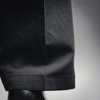 Black pant hem with cuffed bottom and visible stitching