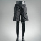 Dark nylon shorts-style pants with elastic waist and side cargo pockets