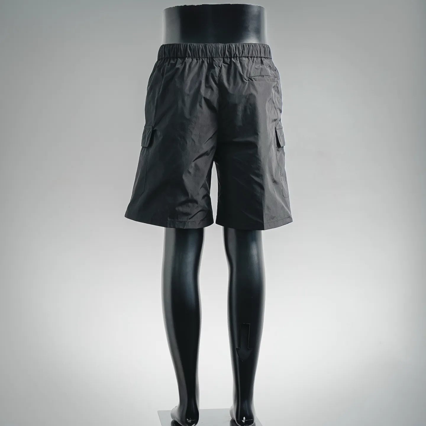 Dark nylon shorts-style pants with side pocket tabs and elastic waist