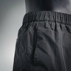 Dark nylon pants waistband with elastic and stitched seam details