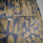 Blue and tan floral leaf fabric print on Prada shorts, close-up view