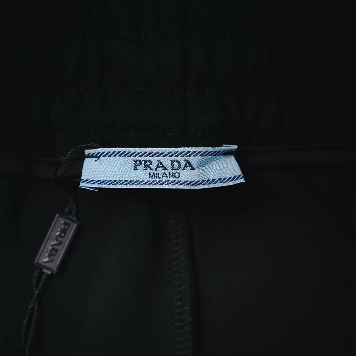 Prada fabric label inside waistband on black shorts