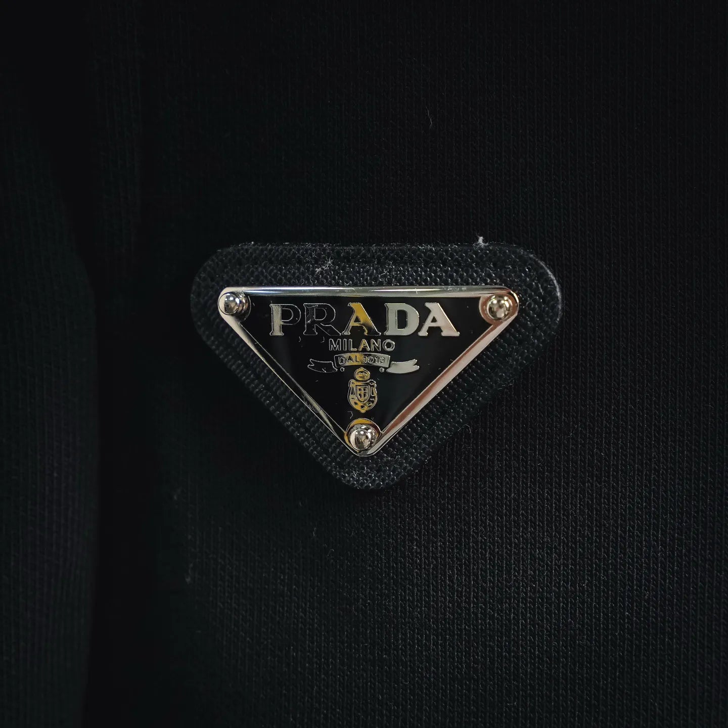 Black Prada logo patch with triangle metal badge on shorts