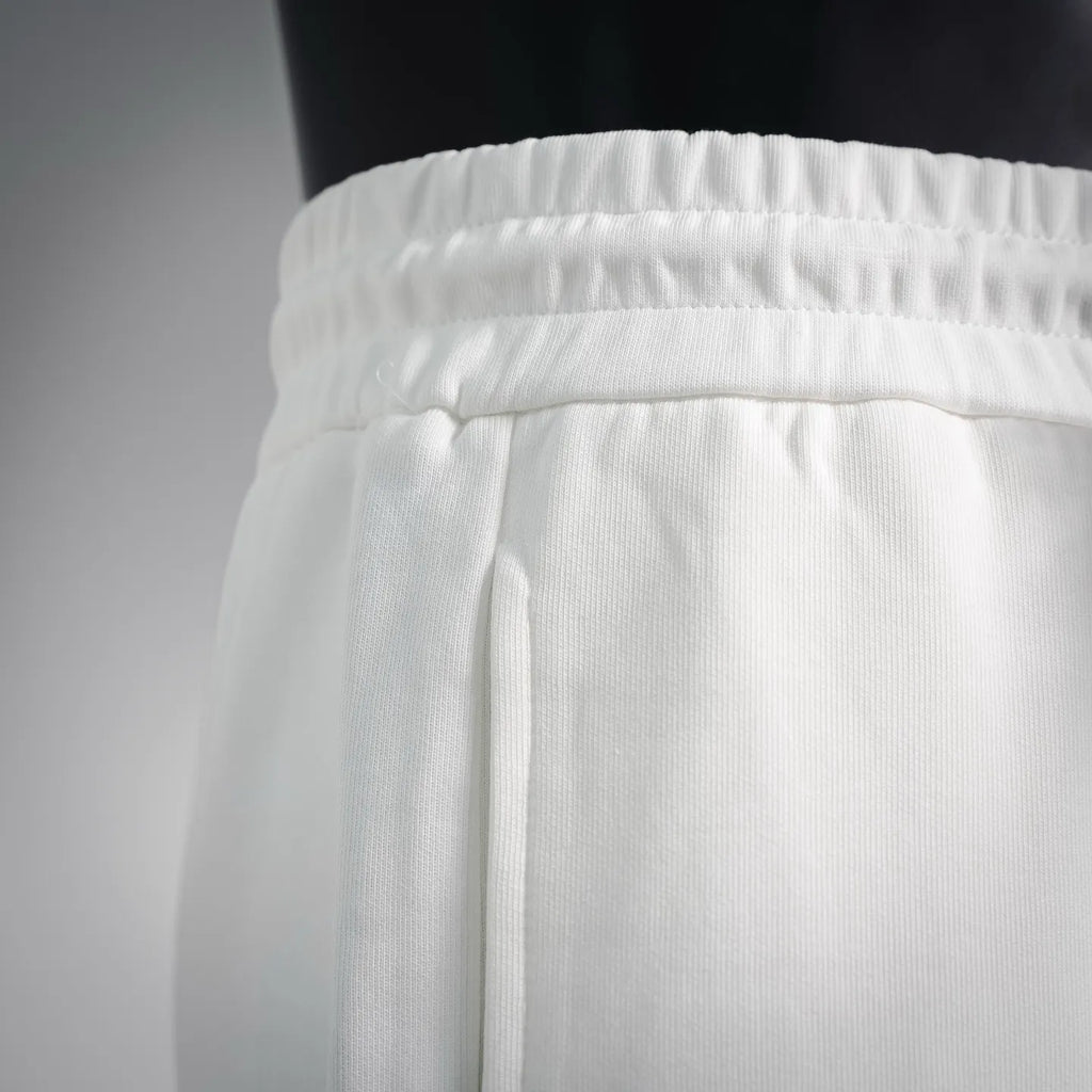 White elastic waistband with drawstring cord opening detail