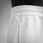 White elastic waistband with drawstring cord opening detail