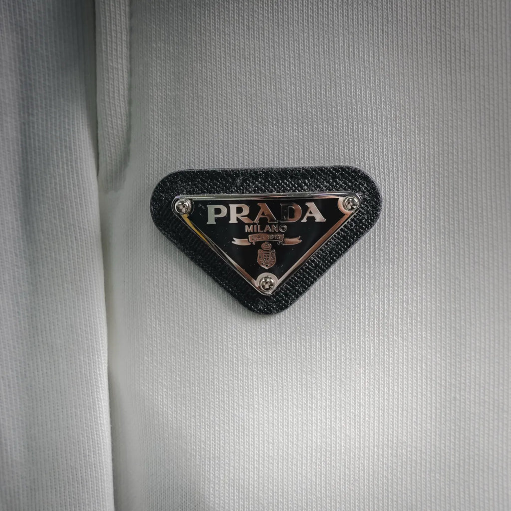 Black triangle PRADA Milano logo patch on white shorts fabric