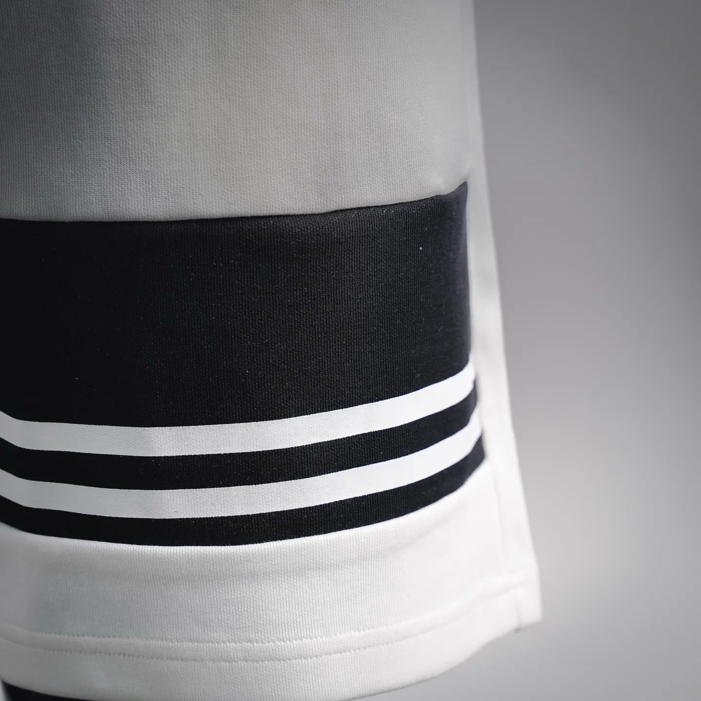 White shorts hem with black-and-white striped band accent