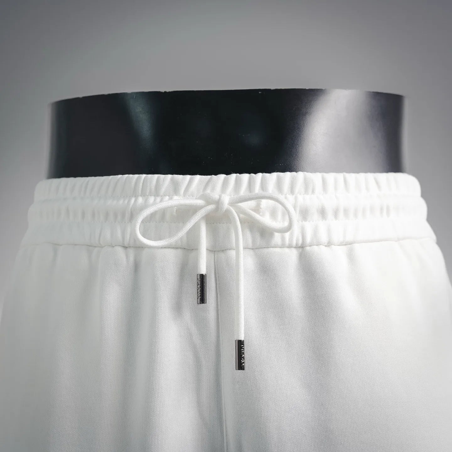 White drawstring shorts with elastic waistband and hanging cord