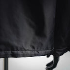 Black jacket hem with stitched trim and mannequin hand