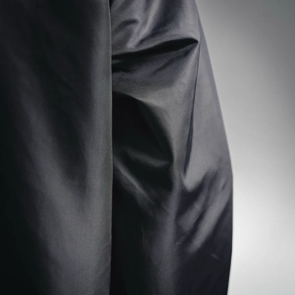 Black jacket side panel with smooth fabric texture