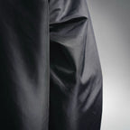 Black jacket side panel with smooth fabric texture