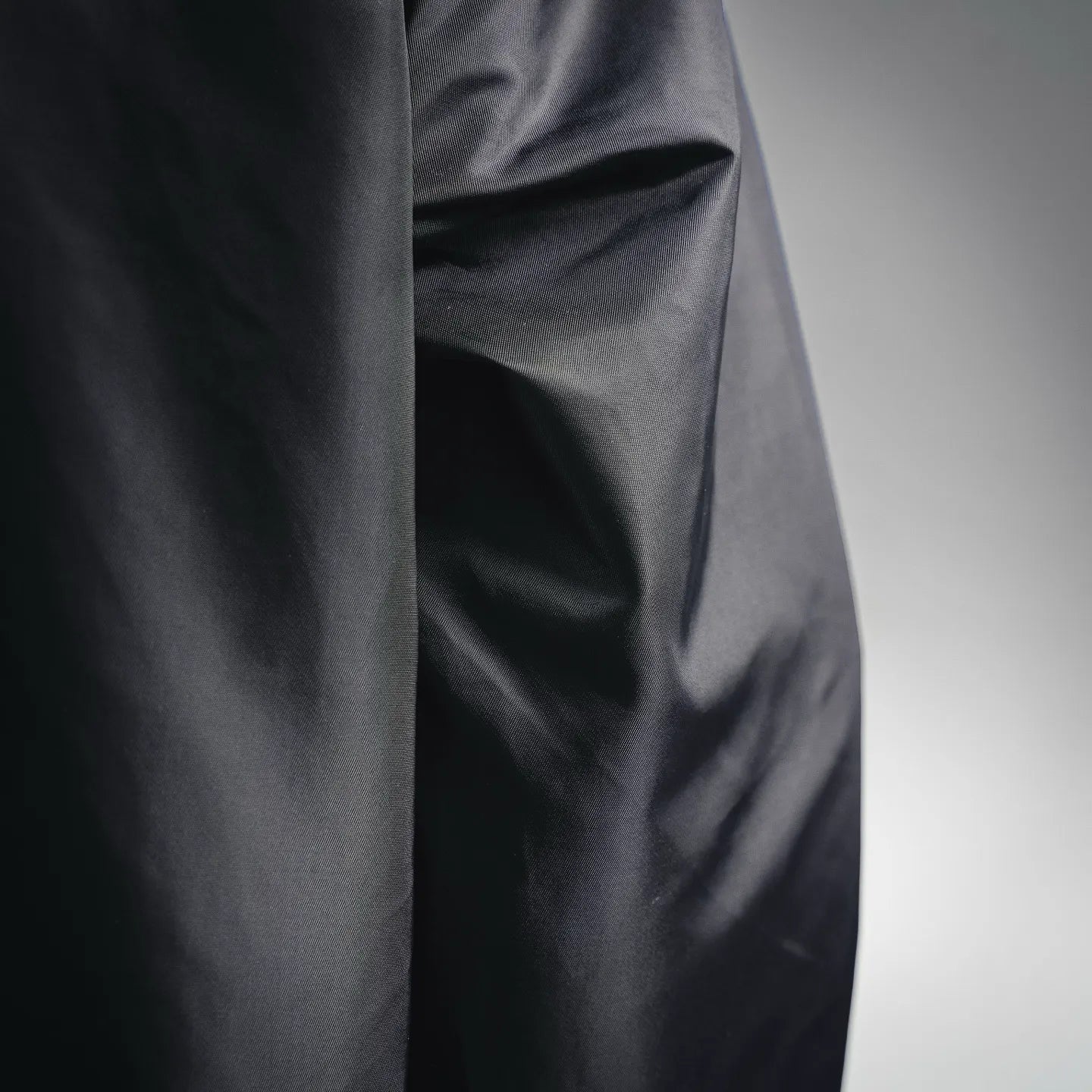Black jacket side panel with smooth fabric texture