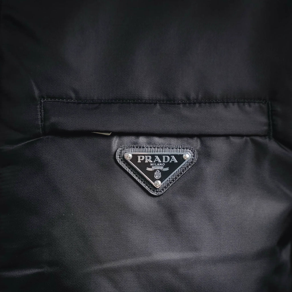 Prada logo triangle patch on front panel of black jacket