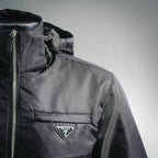 Black hooded jacket with front zipper and Prada chest badge