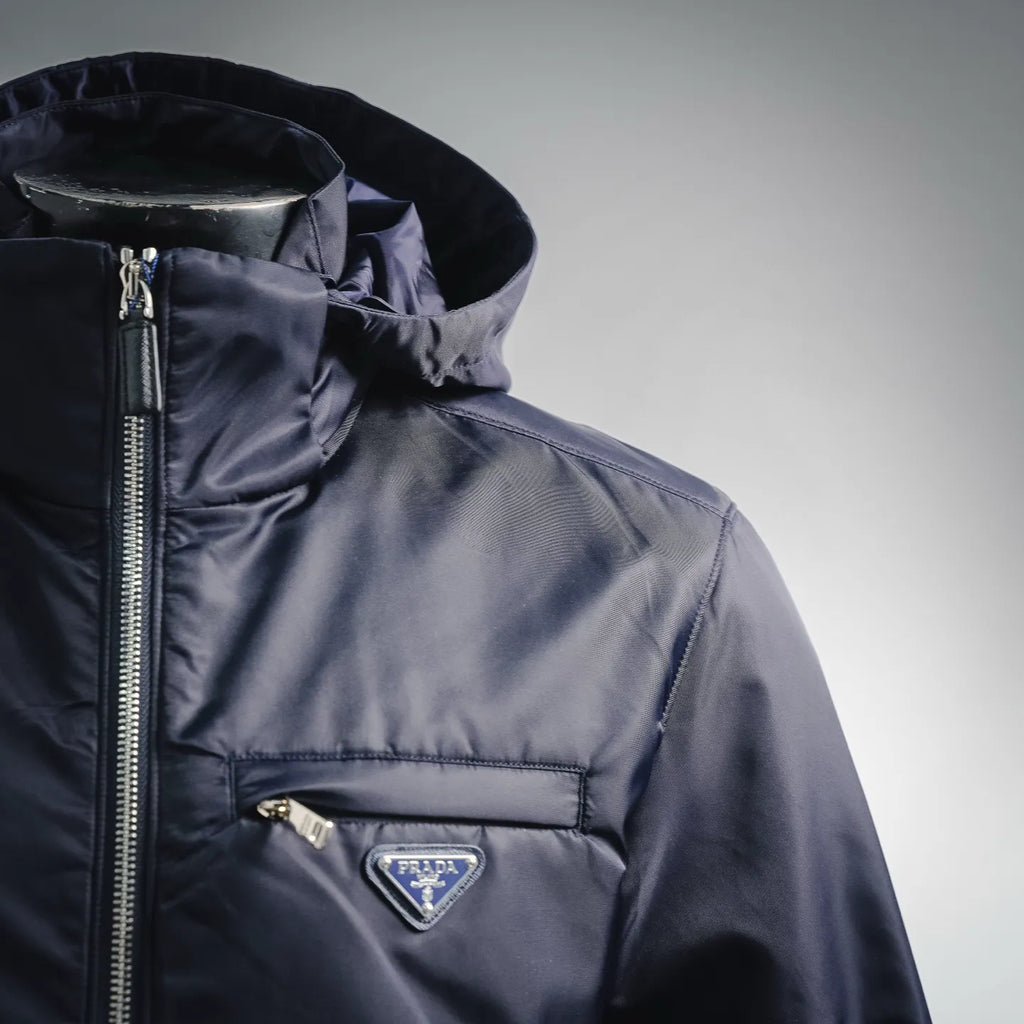 Navy hooded puffer jacket with full zip and triangular Prada chest logo