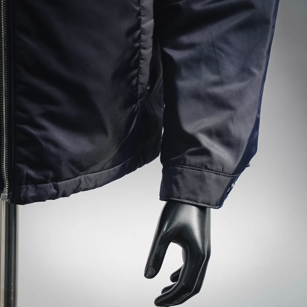 Navy puffer jacket sleeve with elastic cuff and stitched seam