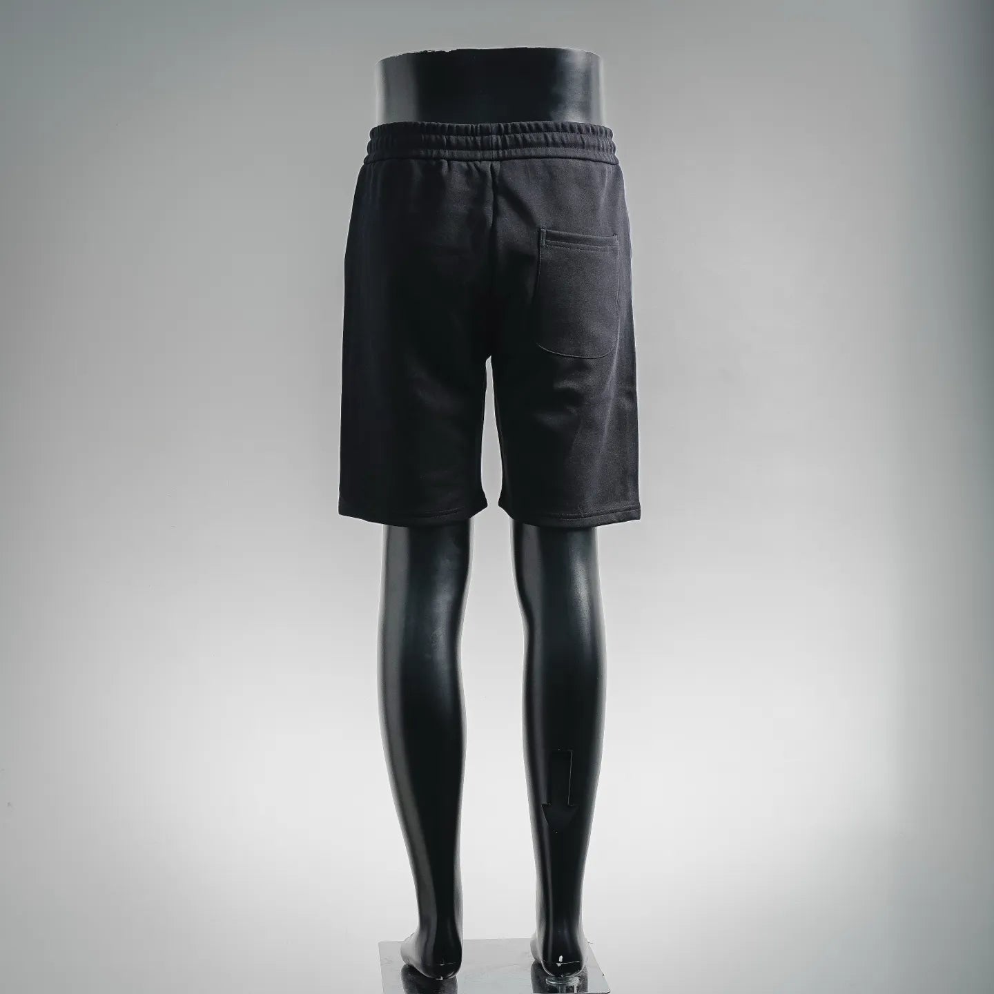 Black logo shorts with elastic waistband, back view on mannequin