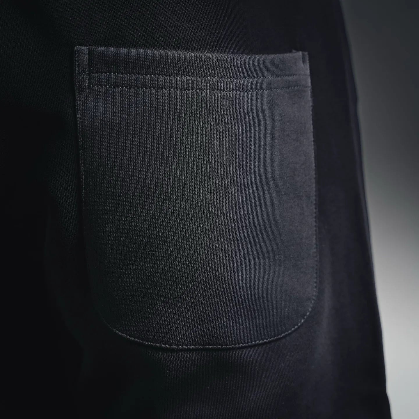Black shorts front pocket with curved opening, stitched edge