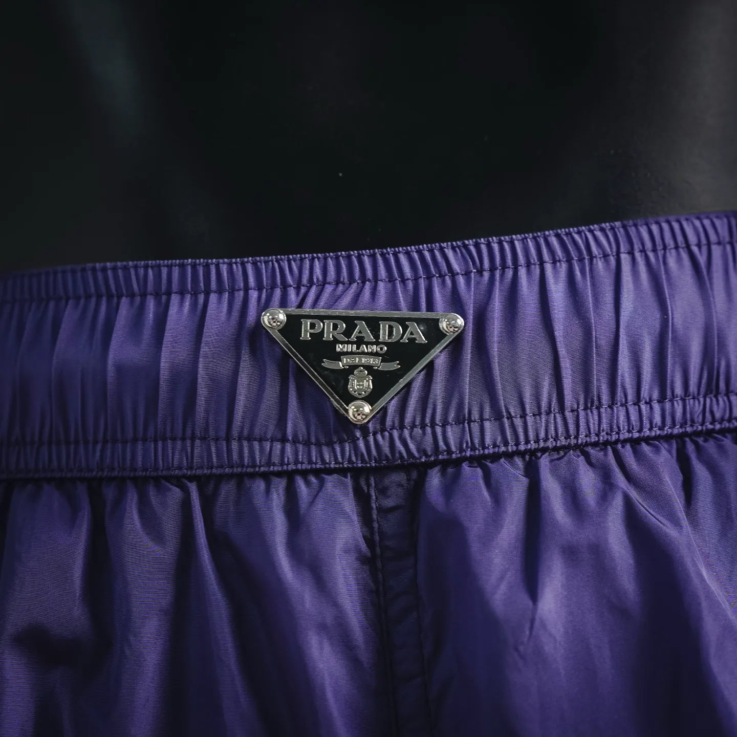 Prada logo patch on purple waistband of nylon shorts