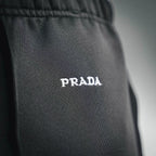 Prada dark pants with 'PRADA' logo print on the leg