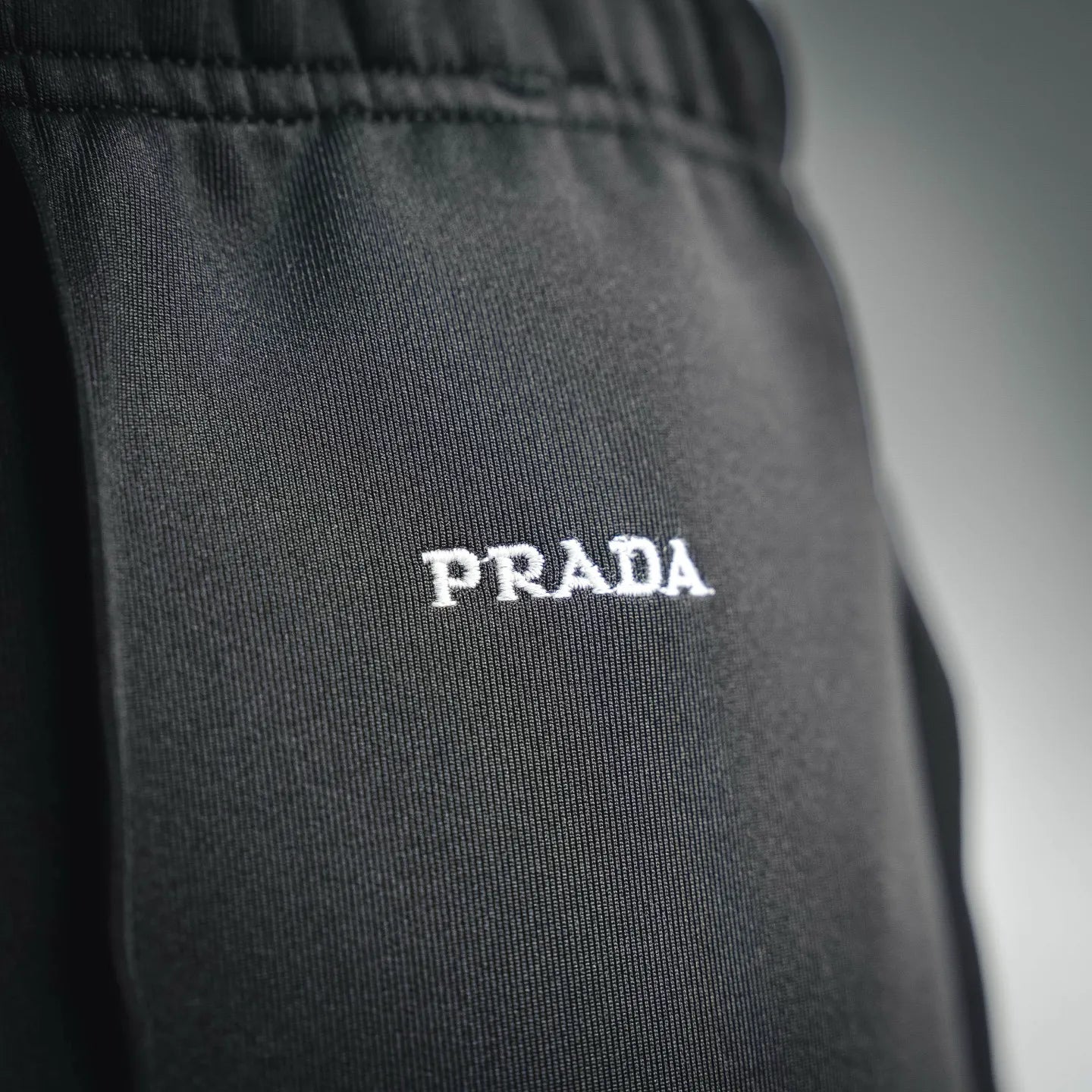 Prada dark pants with 'PRADA' logo print on the leg
