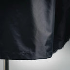 Dark gray jacket hem detail with double-stitched edge and gathered bottom