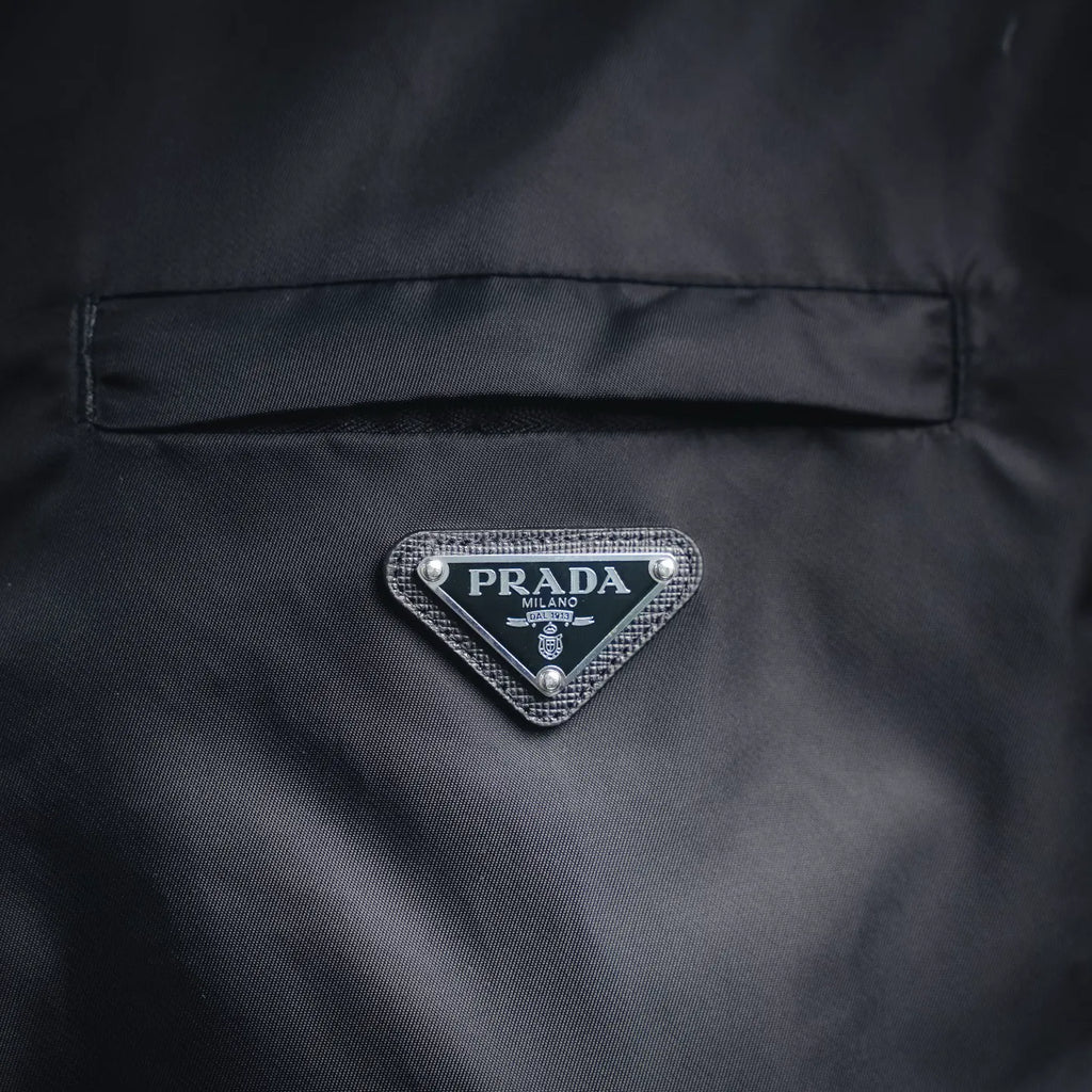 Prada logo badge on dark gray jacket back panel with stitched border