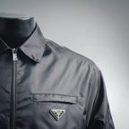 Prada dark gray jacket front shoulder and chest with triangular logo badge