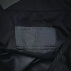 Prada Milano interior label on dark gray jacket with visible zipper track