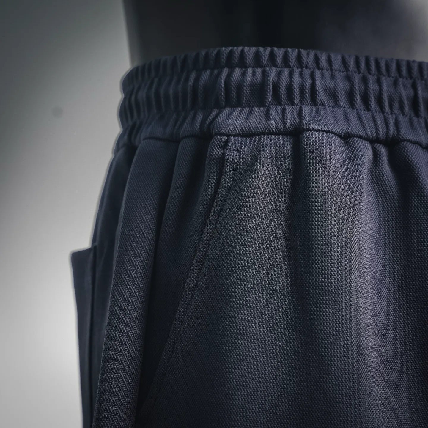 Dark elastic waistband with gathered texture and drawstring ties