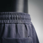 Dark shorts waistband area with small Prada logo patch on front pocket