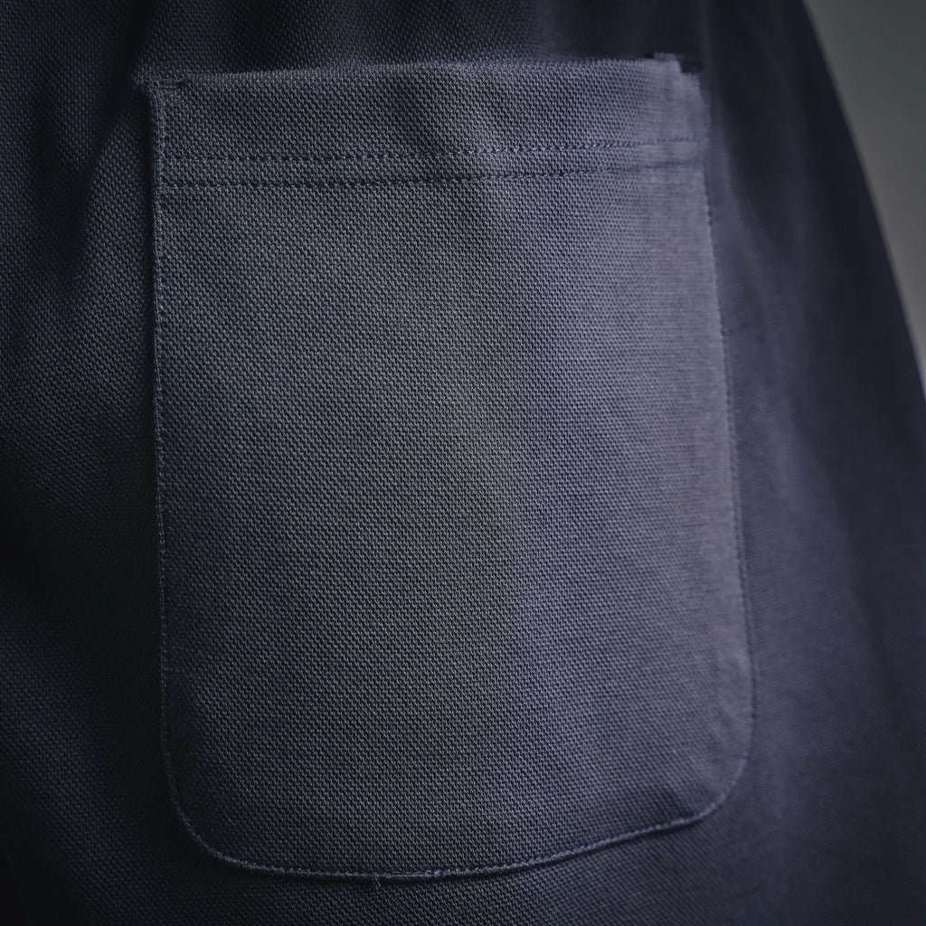 Dark shorts front patch pocket with curved edges and visible seams