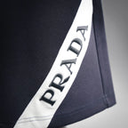 Dark shorts with white side stripe and PRADA lettering patch