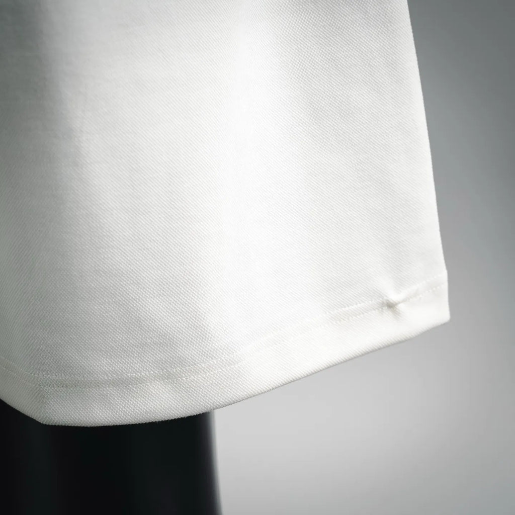 White shorts hem with visible fabric weave and clean stitched edge