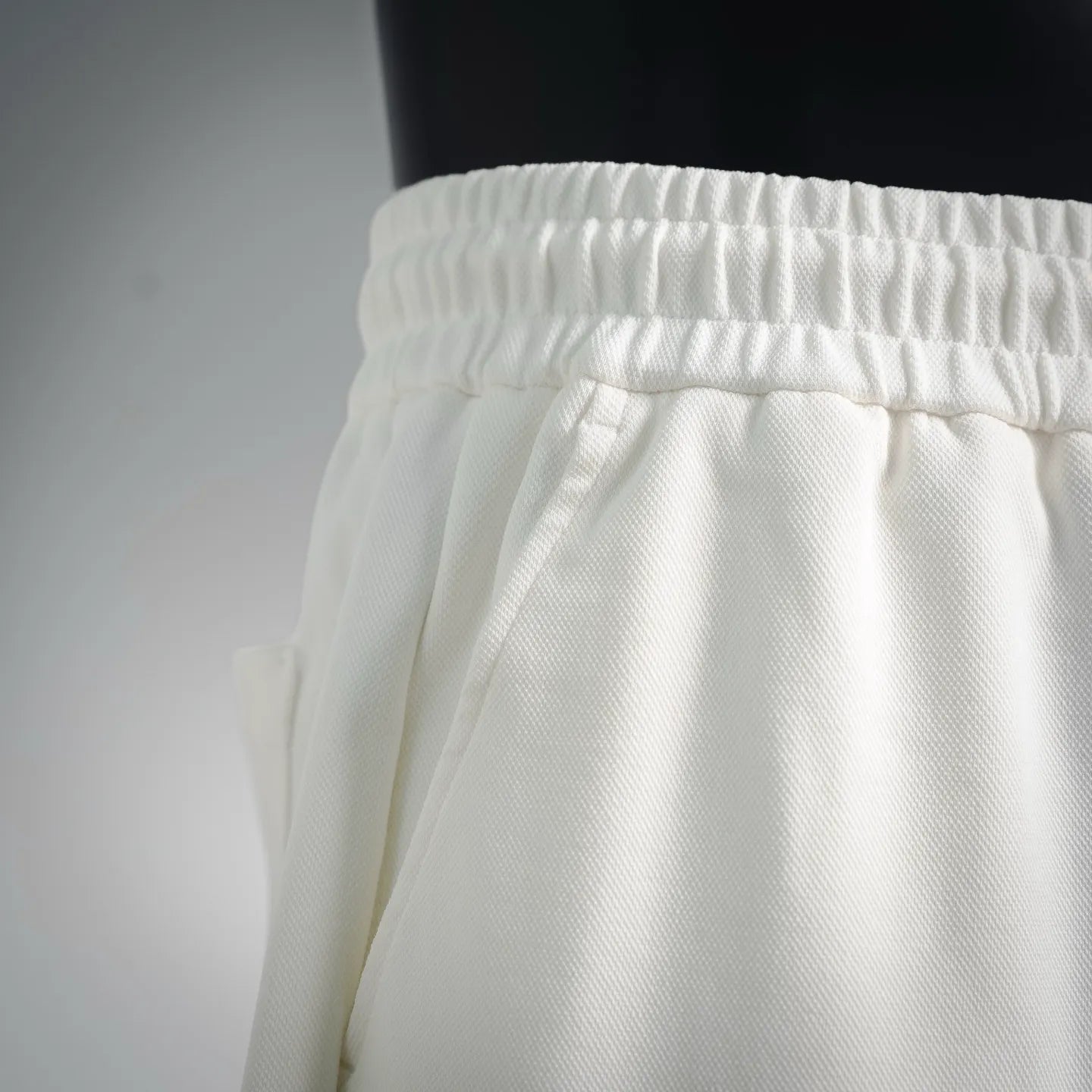 White shorts waistband with elastic gathers and relaxed leg drape