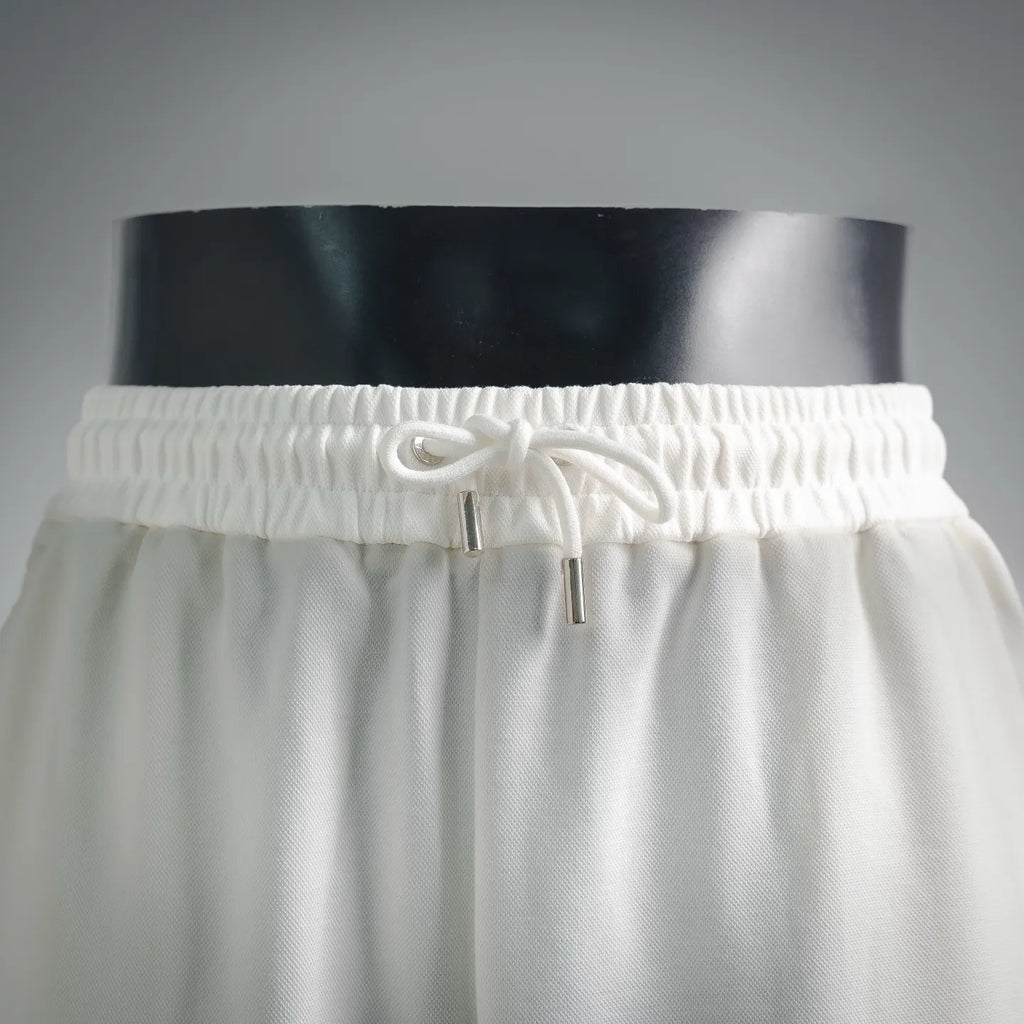White drawstring shorts with elastic waistband and metal eyelets